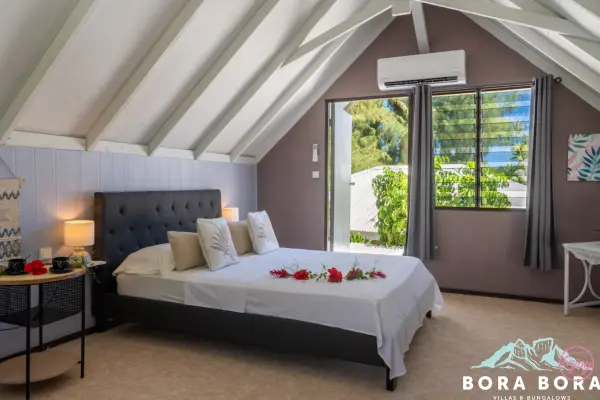 Chambre avec un lit double et un lit simple dans notre maison de vacances à Bora Bora
