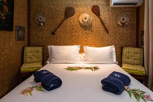 Double bed with Polynesian paddles decor on the wall in the Bora Bora vacation home