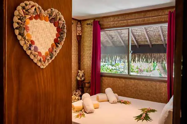 Chambre avec un miroir en forme de cœur entouré de coquillages dans la maison de vacances à Bora Bora