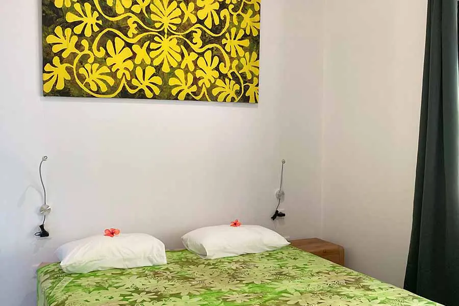 Double bed with artwork on the wall in our vacation home in Bora Bora