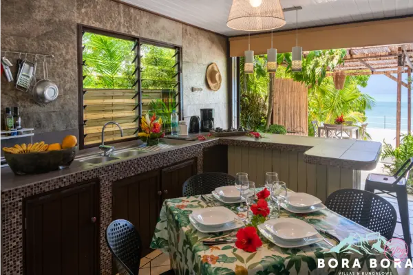 Cuisine avec table à manger et salon avec canapé dans notre maison de vacances à Bora Bora