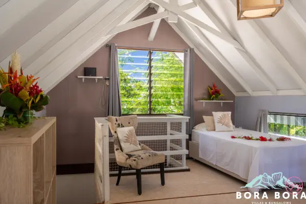 Premier étage avec une fenêtre et un lit simple dans notre maison de vacances à Bora Bora