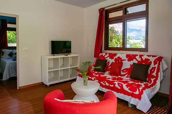 Salon confortable avec petit canapé et petite télévision dans notre maison de vacances à Bora Bora