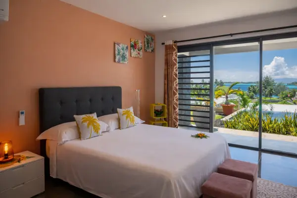 Double bed with stunning ocean view through bay window in Bora Bora