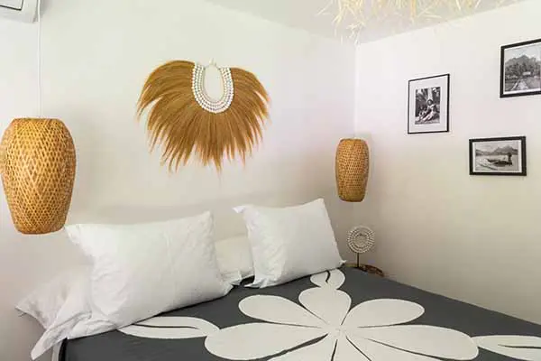 Chambre avec lit double et décoration traditionnelle polynésienne dans notre maison de vacances