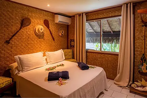 Lit confortable pour deux personnes avec climatisation dans la maison de vacances à Bora Bora